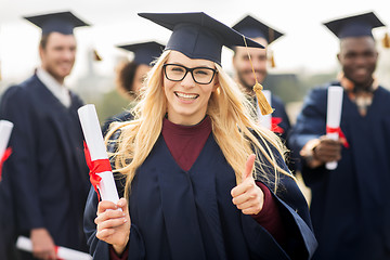 Image showing happy students with diplomas showing thumbs up