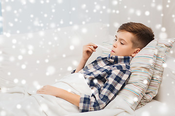 Image showing ill boy with flu and thermometer at home