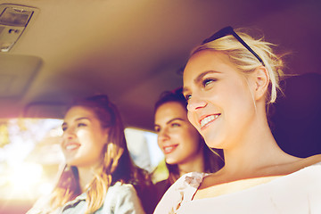 Image showing happy teenage girls or young women driving in car