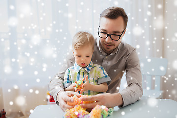 Image showing father and son playing with ball clay at home