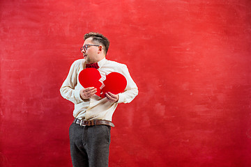 Image showing Young funny man with abstract broken heart and clock