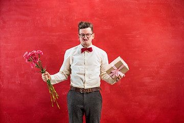 Image showing Young funny man with flowers and gift