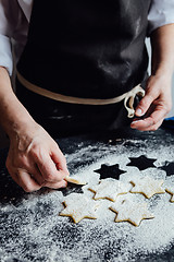 Image showing Person putting raw cookies to flour