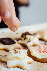 Image showing Person adds cinnamon on top of cookie