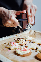 Image showing Cook decorating cookies with chocolate