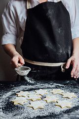 Image showing Person putting raw cookies to flour