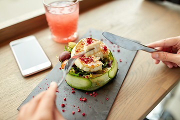 Image showing woman eating goat cheese salad at restaurant