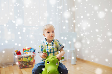 Image showing happy baby boy playing with ride-on toy at home