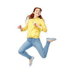 Image showing smiling young woman jumping in air