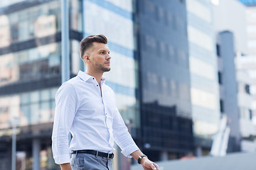 Image showing young man walking along city street