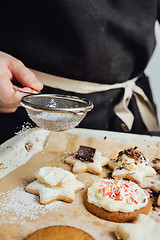 Image showing Person decorating cookies with toppings