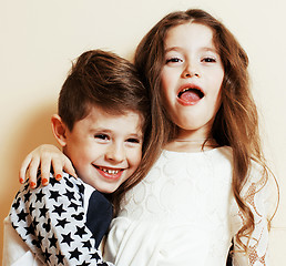 Image showing little cute boy and girl hugging playing on white background, ha