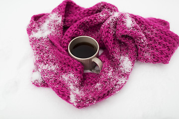 Image showing tea or coffee mug and winter scarf on snow