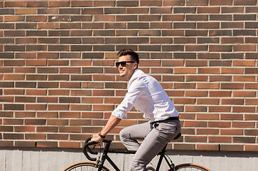 Image showing young man riding bicycle on city street