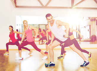 Image showing group of smiling people working out with dumbbells