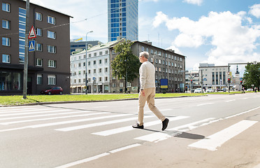 Image showing senior man walking along city crosswalk