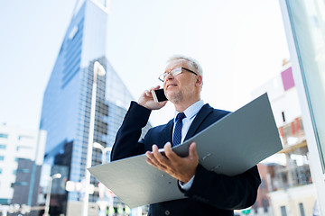 Image showing senior businessman calling on smartphone in city