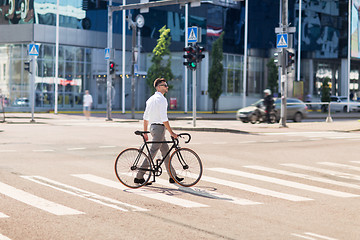 Image showing young man with bicycle on crosswalk in city