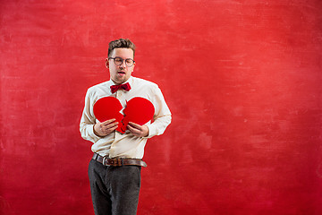 Image showing Young funny man with abstract broken heart and clock