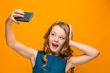 Image showing The face of playful happy teen girl with phone