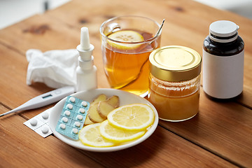 Image showing drugs, thermometer, honey and cup of tea on wood