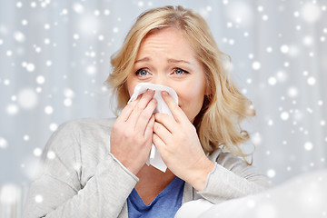 Image showing ill woman blowing nose to paper napkin