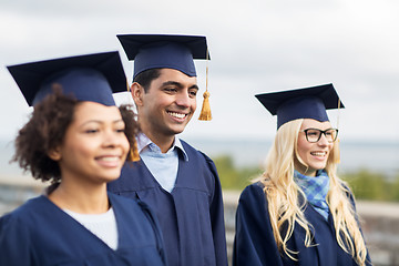 Image showing happy students or bachelors in mortar boards