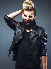 Image showing young attractive bearded hipster man gesturing emotional screaming in studio sucsess