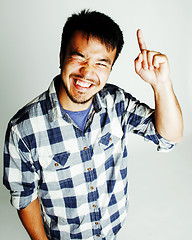 Image showing young cute asian man on white background gesturing emotional, pointing, smiling, lifestyle people concept