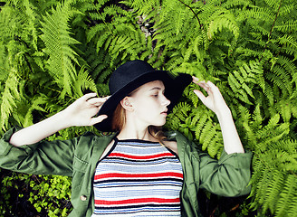 Image showing Pretty young blond girl hipster in hat among fern, vacation in green forest