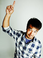 Image showing young cute asian man on white background gesturing emotional, pointing, smiling, lifestyle people concept