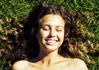 Image showing young cute summer girl on green grass outside relaxing happy smiling close up, lifestyle people concept