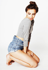 Image showing pretty sexy young woman in denim shorts and bodysuit posing against white wall, lifestyle people concept