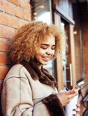 Image showing young pretty african american women drinking coffee outside in cafe, modern business woman lifestyle concept