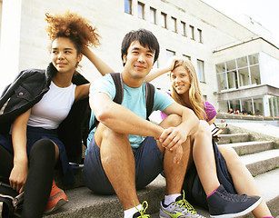 Image showing cute group of teenages at the building of university with books 