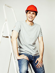 Image showing young real hard worker man isolated on white background on ladder smiling posing, business concept