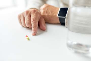 Image showing close up of old man hand with pill and smart watch