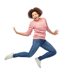 Image showing happy african american woman jumping over white