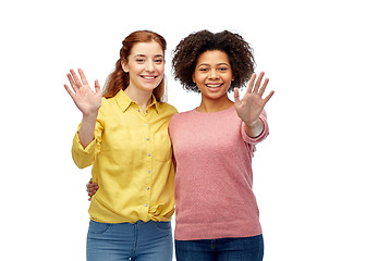 Image showing happy smiling women waving hands over white