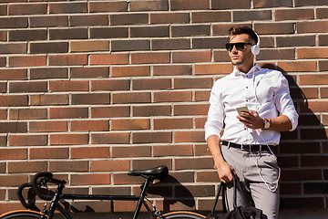 Image showing man with headphones, smartphone and bicycle