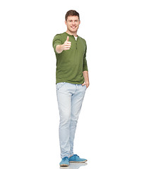 Image showing young smiling man showing thumbs up over white