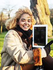 Image showing young cute blond african american girl student holding tablet and smiling, lifestyle people concept