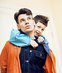 Image showing young handsome father with his son fooling around at home, lifestyle people concept