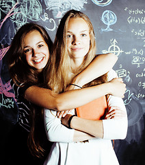 Image showing back to school after summer vacations, two teen real girls in classroom with blackboard painted together