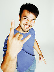 Image showing young cute asian man on white background gesturing emotional, pointing, smiling, lifestyle people concept