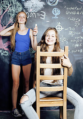 Image showing back to school after summer vacations, two teen real girls in classroom with blackboard painted together