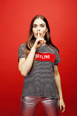 Image showing young pretty emitonal posing teenage girl on bright red background, happy smiling lifestyle people concept