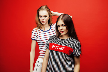 Image showing two best friends teenage girls together having fun, posing emotional on red background, besties happy smiling, lifestyle people concept