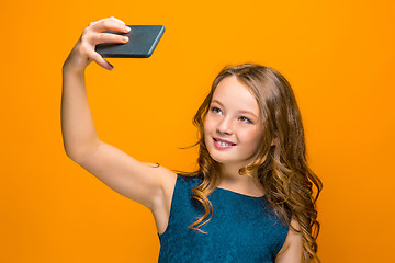 Image showing The face of playful happy teen girl with phone