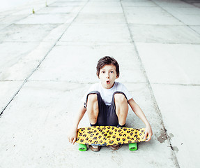 Image showing little cute boy with skateboard on playground alone training, copyspace, lifestyle people concept